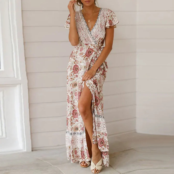 Chic women's V-neck wrap maxi dress, featuring a flattering fit, flutter sleeves & tiered design. Ideal for guests.