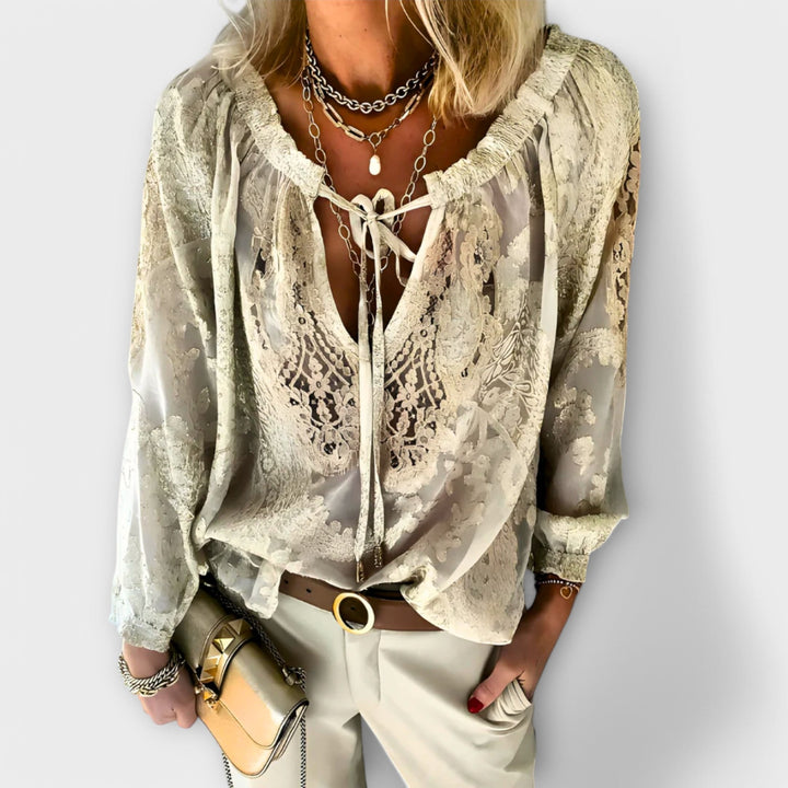 Sophisticated women's blouse featuring intricate lace detailing and a flattering tie-neck, great for work or a night out.