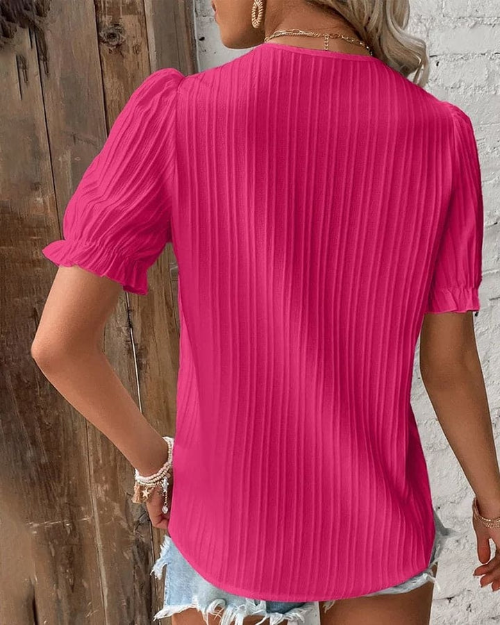 Close-up of elegant white women's V-neck lace blouse. Delicate lace detail, perfect for chic spring/summer style.