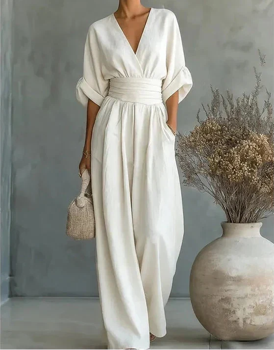 Women's elegant wide-leg wrap jumpsuit featuring a flattering bodice and practical pockets. Stylish.