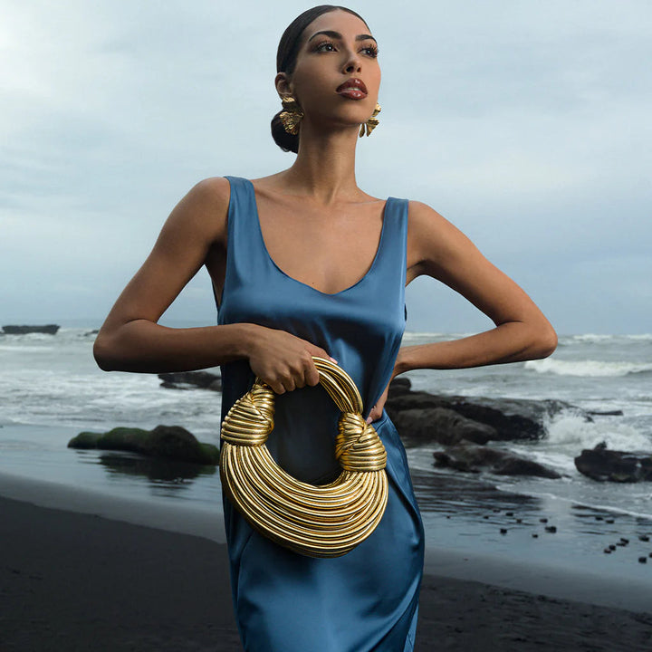 Versatile gold woven handbag for women, an elegant fashion accessory with unique knot detail.