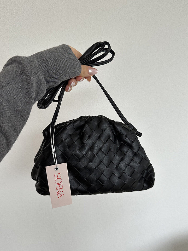 Elegant women's woven shoulder bag displayed on a clean surface. Modern, compact & versatile for any outfit.