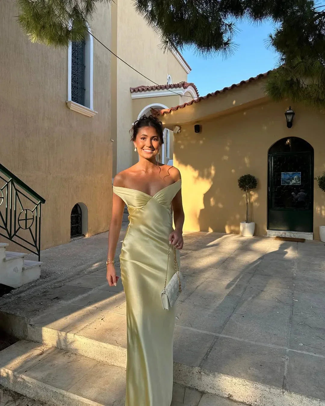 Beautiful women's yellow off-shoulder maxi evening gown with a flattering silhouette & a coordinating clutch bag.