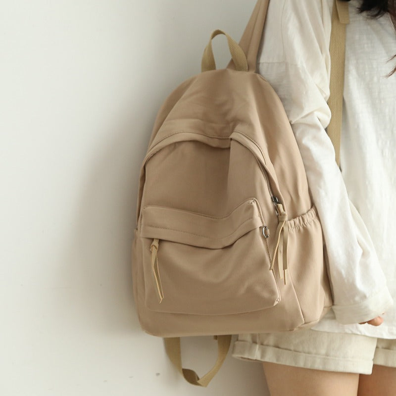 Front view of a sleek black everyday backpack, featuring multiple pockets for easy organization.