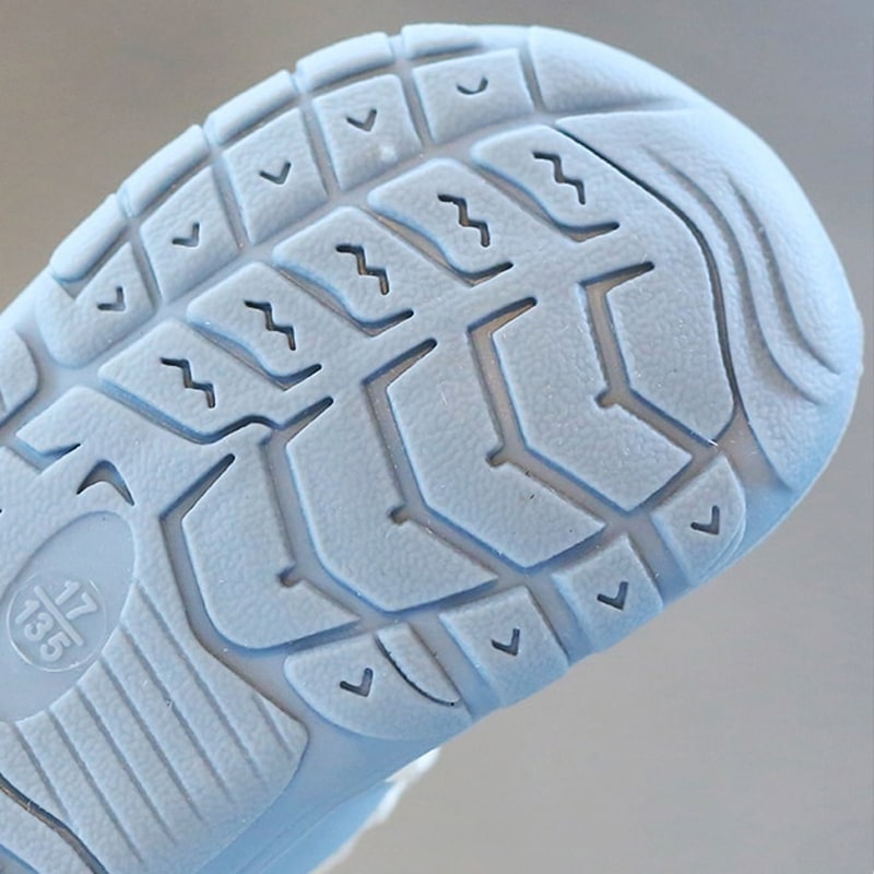 Parent putting on easy-on baby barefoot shoes, ensuring a secure, flexible fit for natural development.