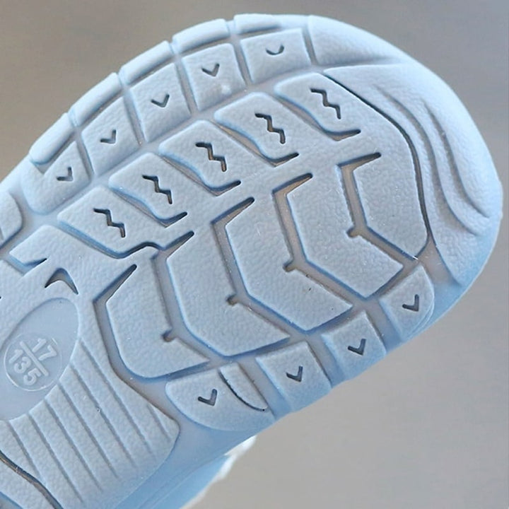 Parent putting on easy-on baby barefoot shoes, ensuring a secure, flexible fit for natural development.