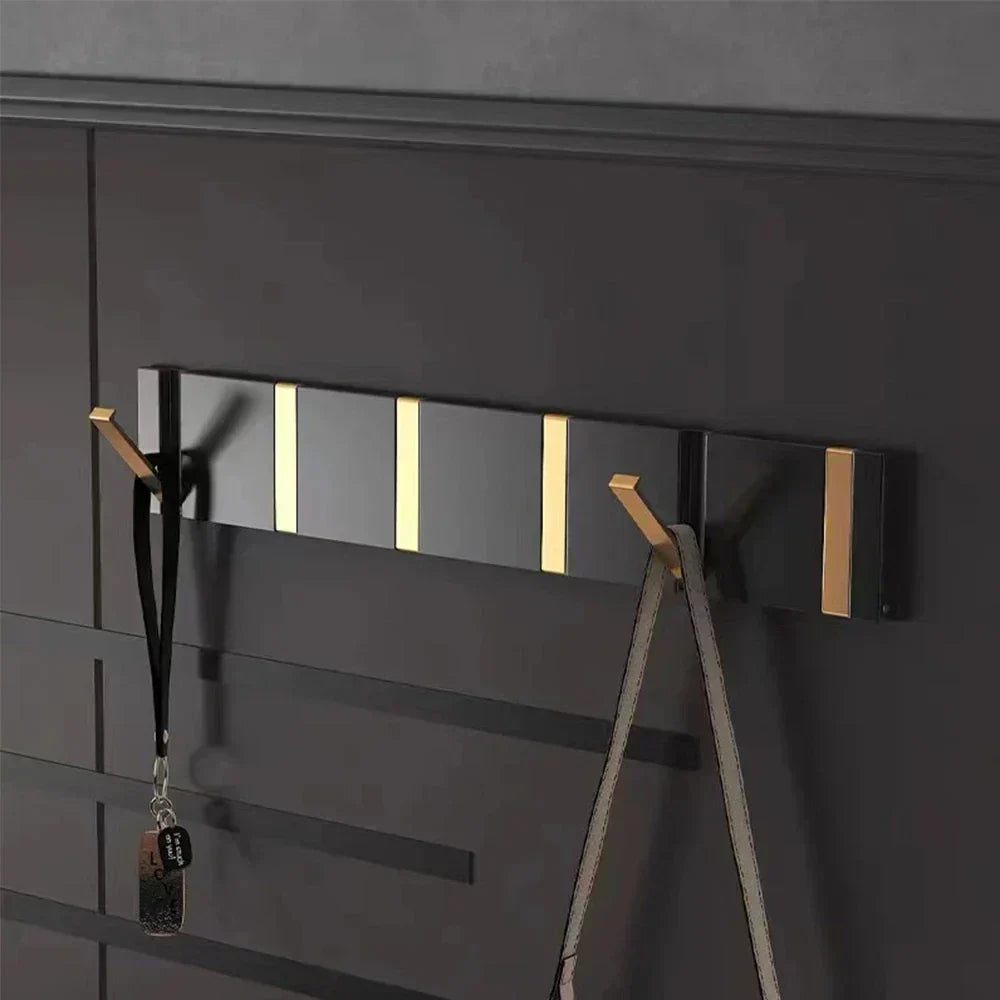 Gold foldable wall hook for modern bathroom, towel & robe organization, space-saving.