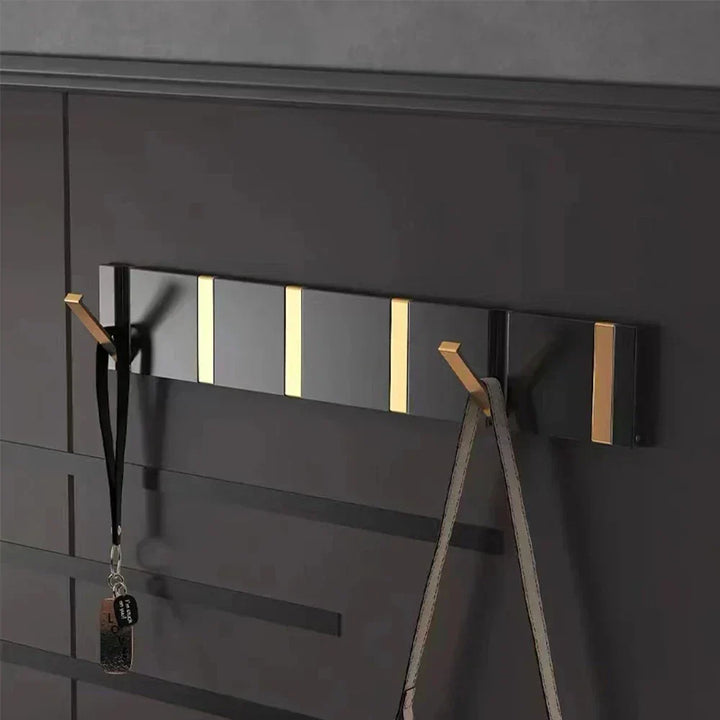 Gold foldable wall hook for modern bathroom, towel & robe organization, space-saving.