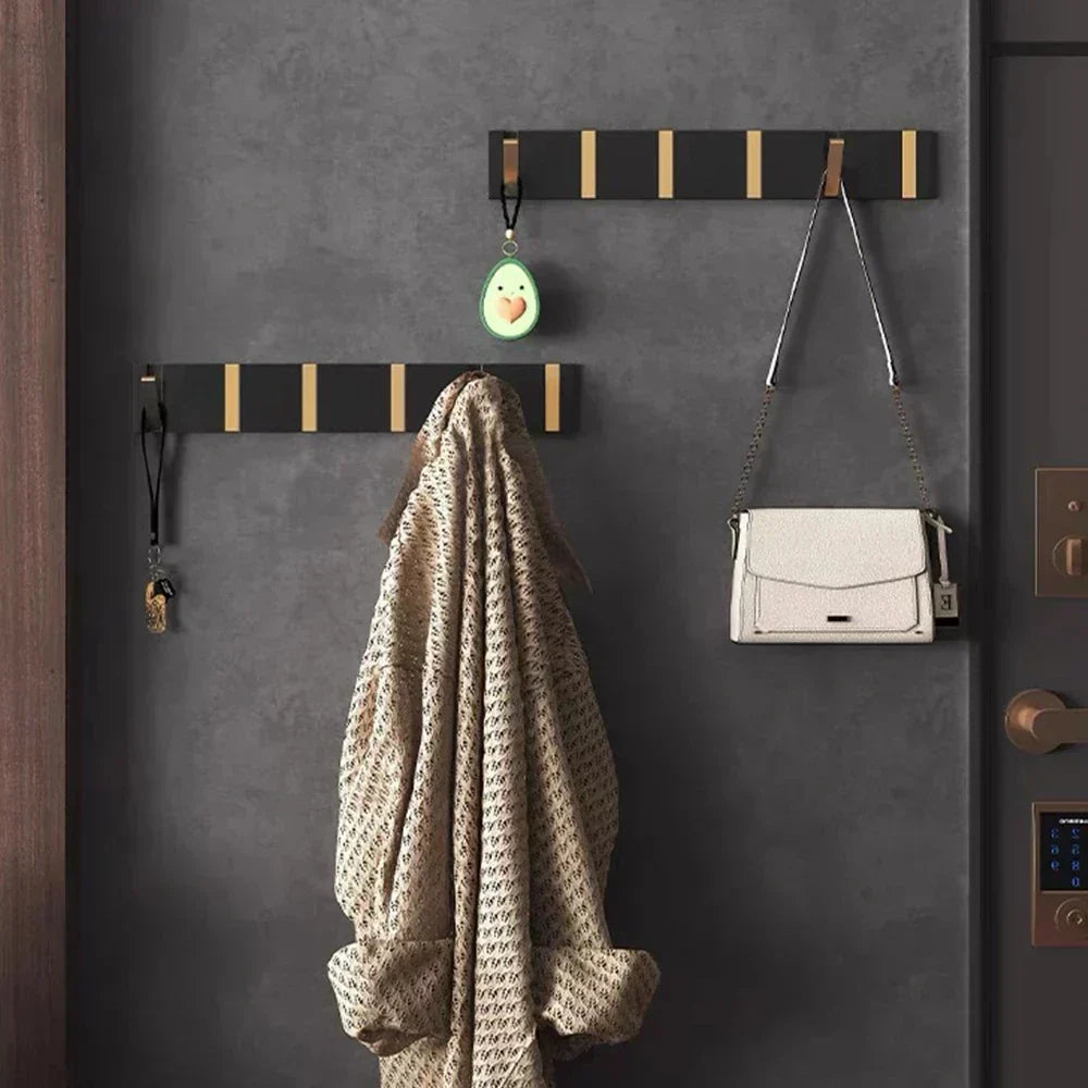 Black foldable coat hook for kitchen, organizing aprons & utensils, space-saving design.