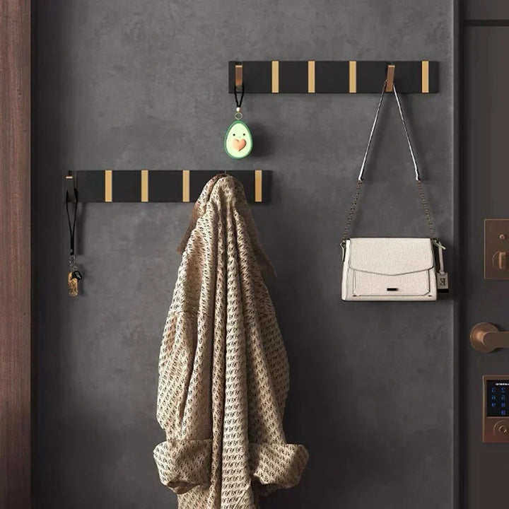 Black foldable coat hook for kitchen, organizing aprons & utensils, space-saving design.