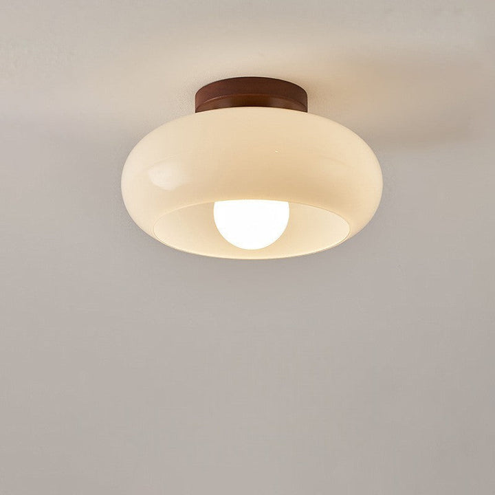 Wooden French Bauhaus ceiling lamp with opal glass diffuser, casting a warm, inviting light for modern interiors.