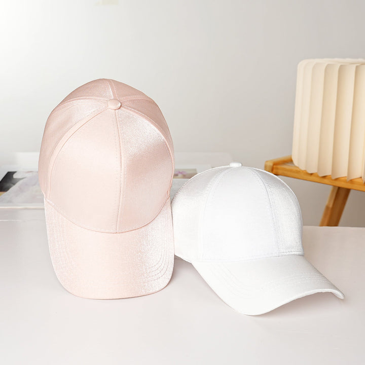 Close-up of a Women's Sporty Satin Baseball Cap showing the smooth fabric & curved brim, chic headwear.