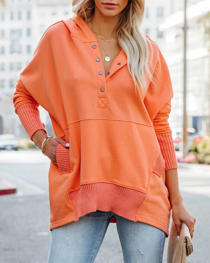 Close-up on the side pockets of a women's longline hooded tunic sweatshirt, practical and stylish.