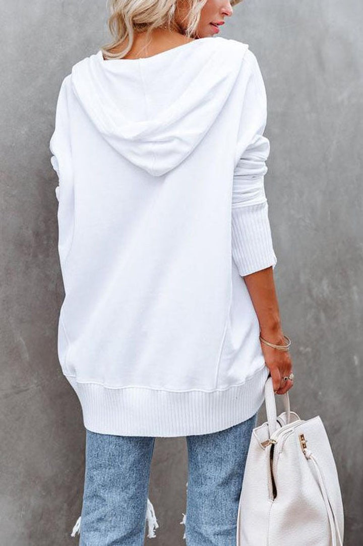 Side profile of a woman wearing a relaxed fit longline hooded sweatshirt tunic, perfect for everyday wear.