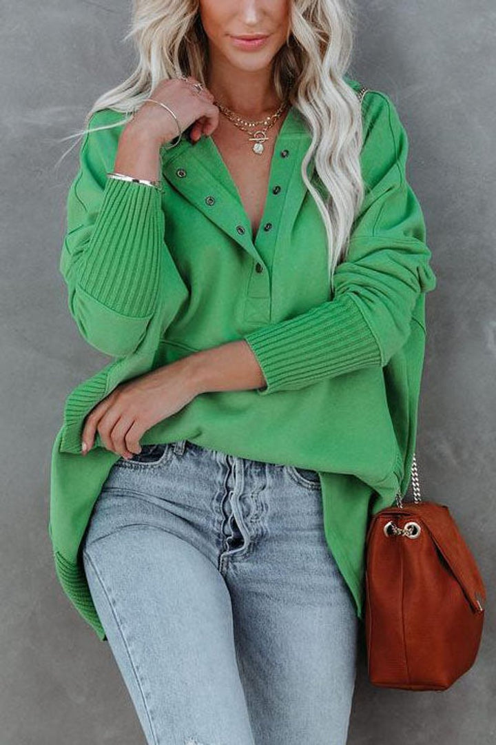 Woman modeling a black longline hooded tunic sweatshirt, perfect for everyday casual style and warmth.