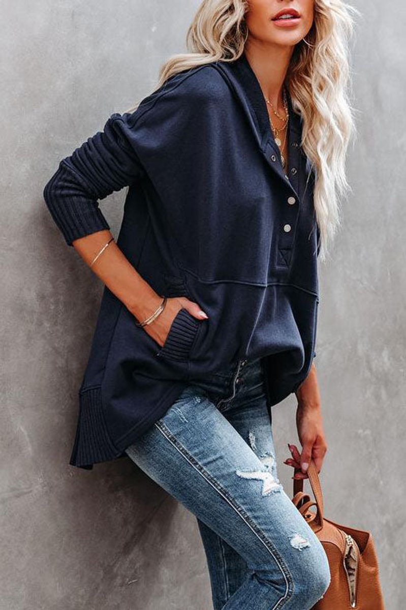 Stylized shot of a women's cozy longline hooded sweatshirt with tunic length and practical pockets.