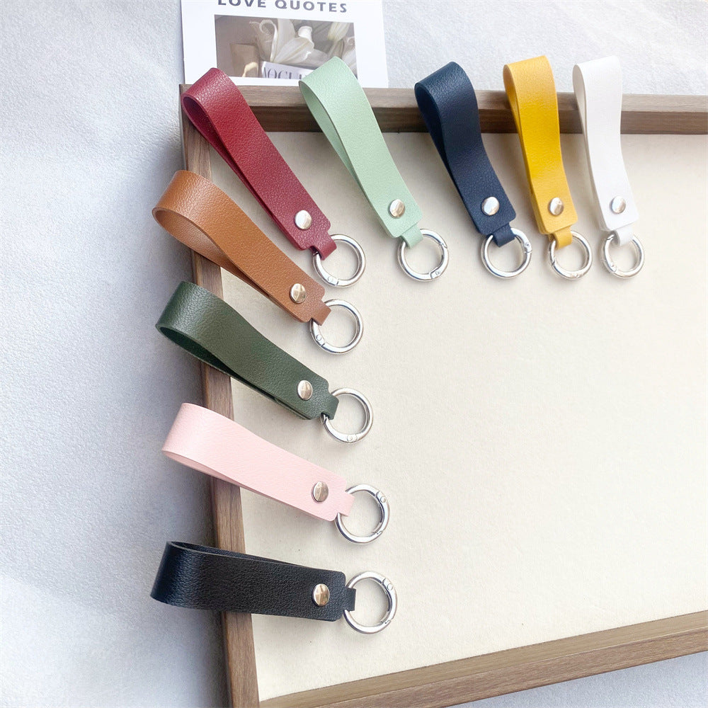 Minimalist black genuine leather key holder. Elegant everyday carry, a chic bag charm accessory.
