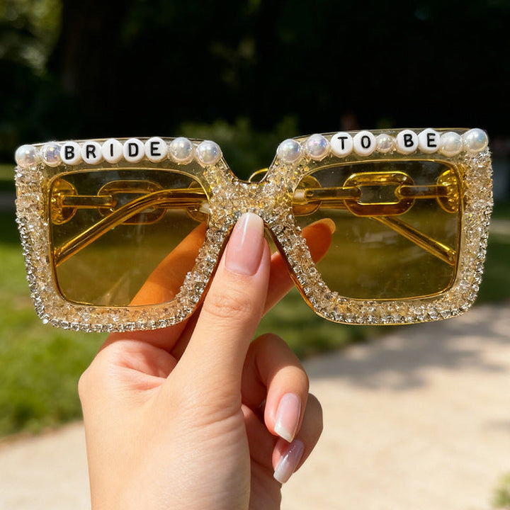 Close-up of white pearl & sparkling rhinestone women's bridal sunglasses for a glamorous look.