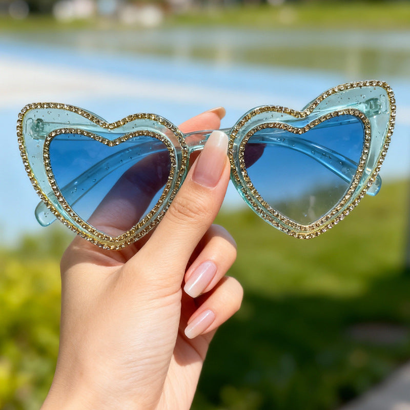 High-fashion women's heart-frame sunglasses. Featuring glamorous rhinestones & essential UV protection.