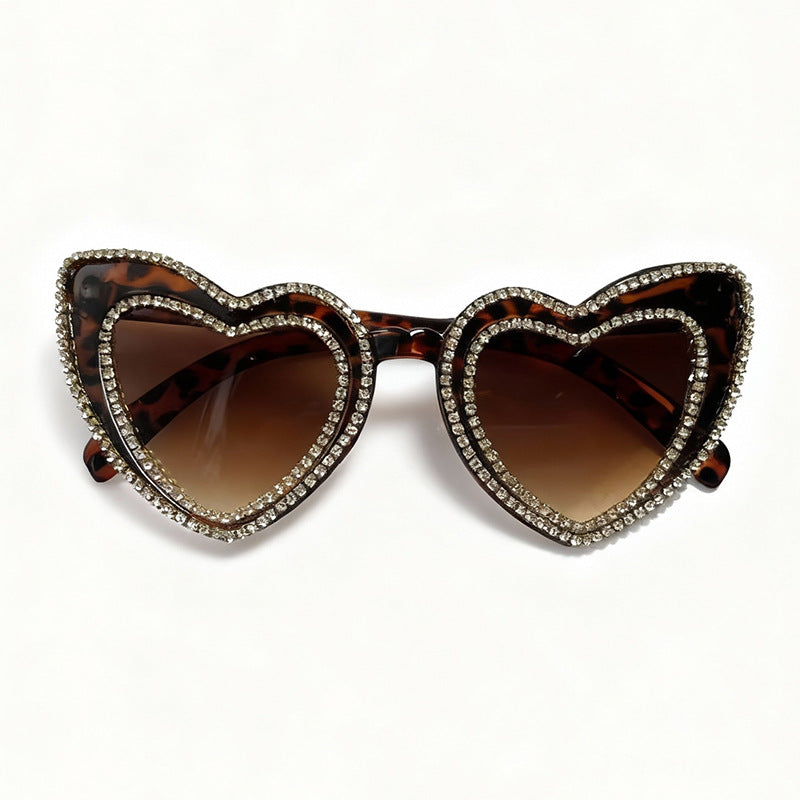 Trendy heart-shaped rhinestone sunglasses for women. Fashionable summer shades with glamorous sparkle.