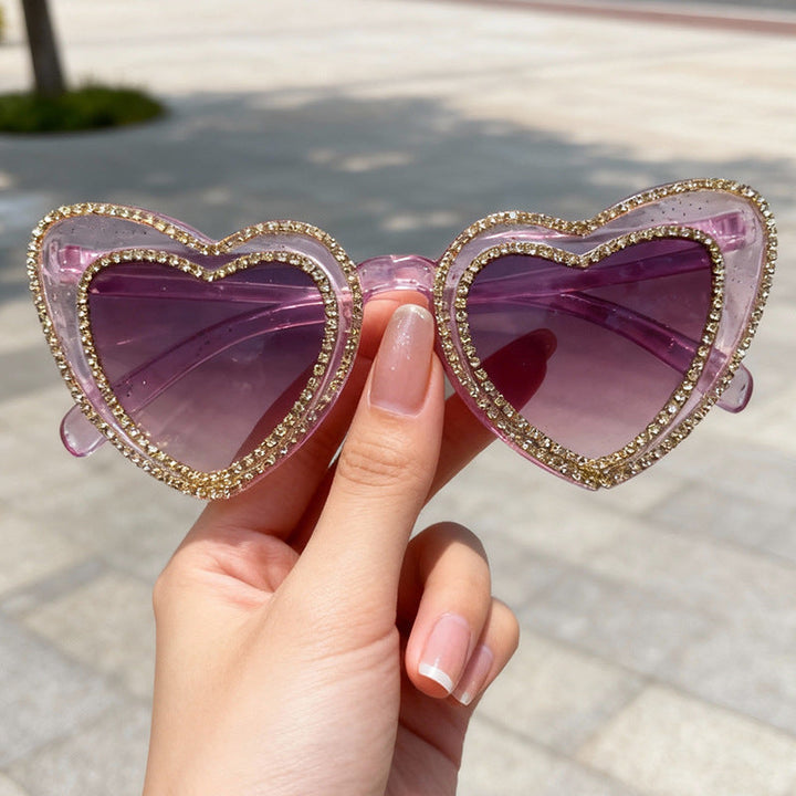 Stylish women's heart sunglasses with shiny rhinestone details. Chic UV protection for sunny days.