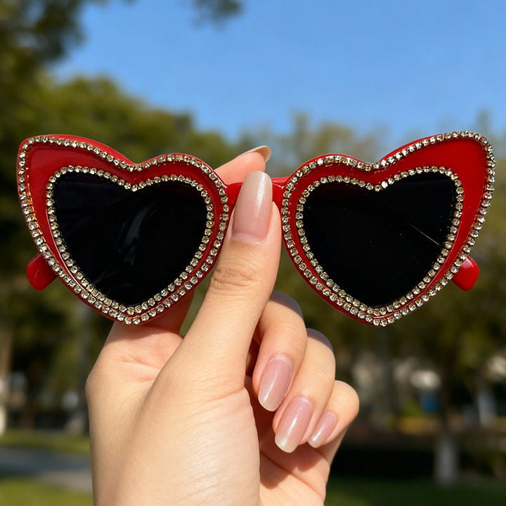 Full view of glamorous women's heart-frame sunglasses, showcasing trendy design and rhinestones.