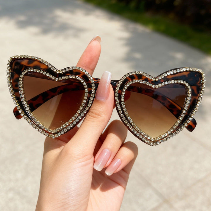 Women's elegant heart frame sunglasses. Rhinestone embellished, offering UV protection as a chic accessory.