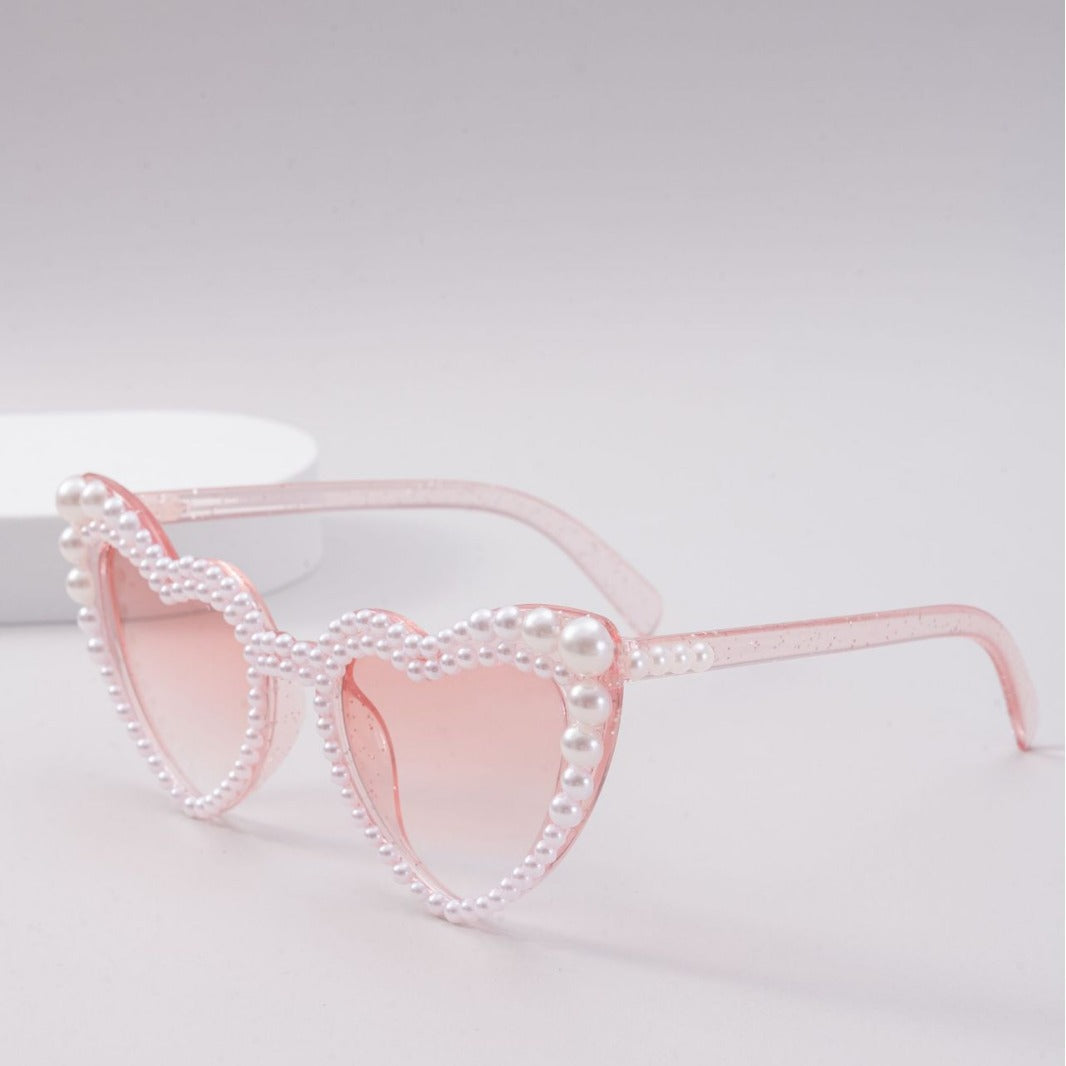 Elegant heart-shaped women's sunglasses featuring delicate pearl accents, trendy fashion accessory.