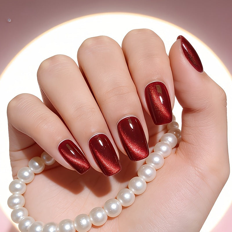 Glossy wine red cat eye metallic press-on nails for women, featuring a stunning reflective finish. Easy to apply fake nails.