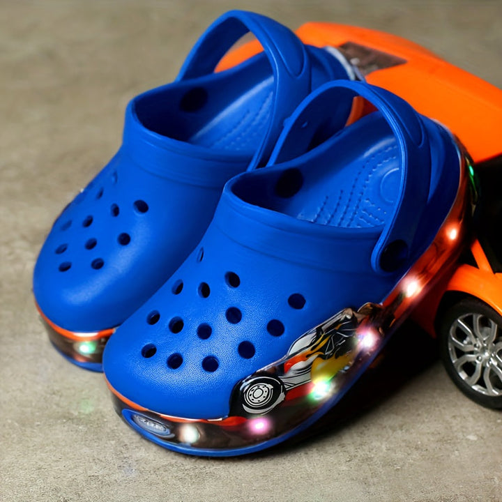 Pair of fun glow-in-the-dark clogs for kids, showing textured anti-slip sole. Ideal breathable play shoes.
