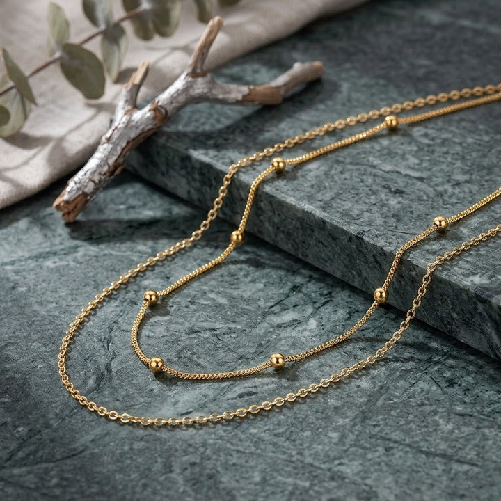 Women's elegant gold layered necklace with white accents, a perfect fashion accessory.