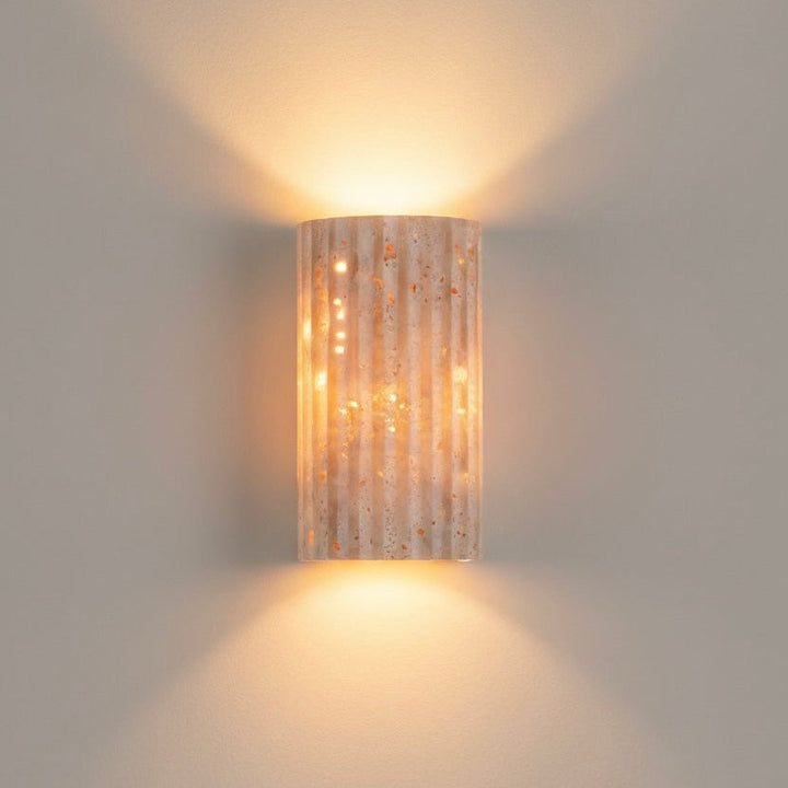 Contemporary indoor wall sconce, textured finish, providing warm LED ambient lighting.