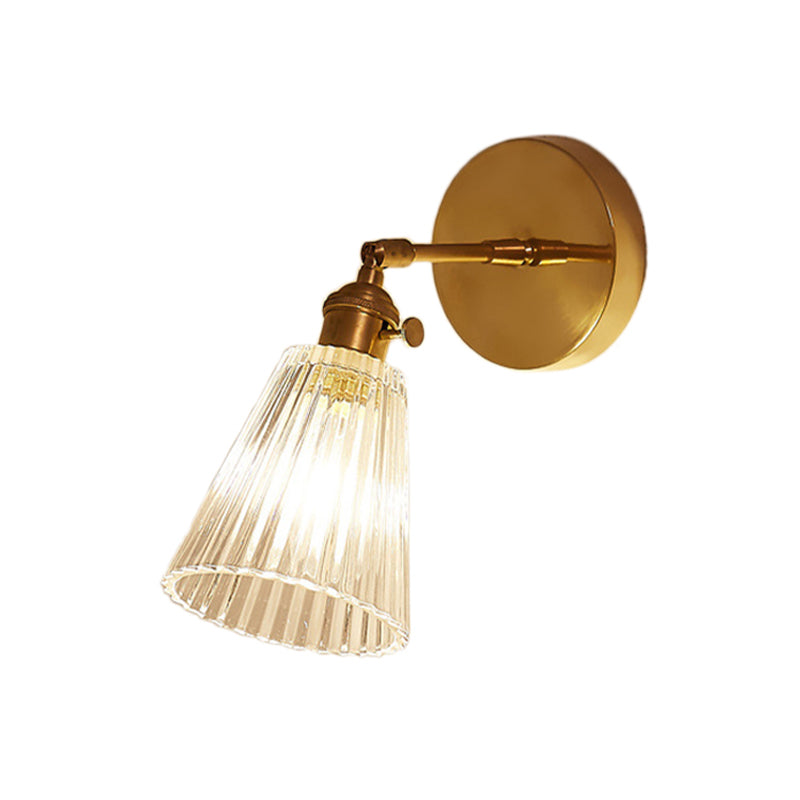 Industrial brass wall sconce with tapered clear glass shade, single light, modern home accent lighting for entryways.