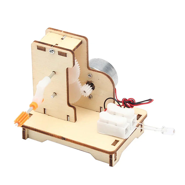 Child's hand holding a finished wooden electric toy boat. Educational STEM kit.