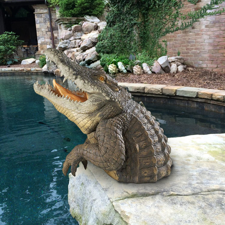 Alligator garden statue among plants, realistic resin wildlife art for outdoor nature-inspired decor.