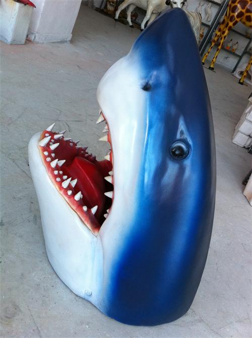 Outdoor scene with alligator & shark statues, creating a lifelike wildlife display in garden.