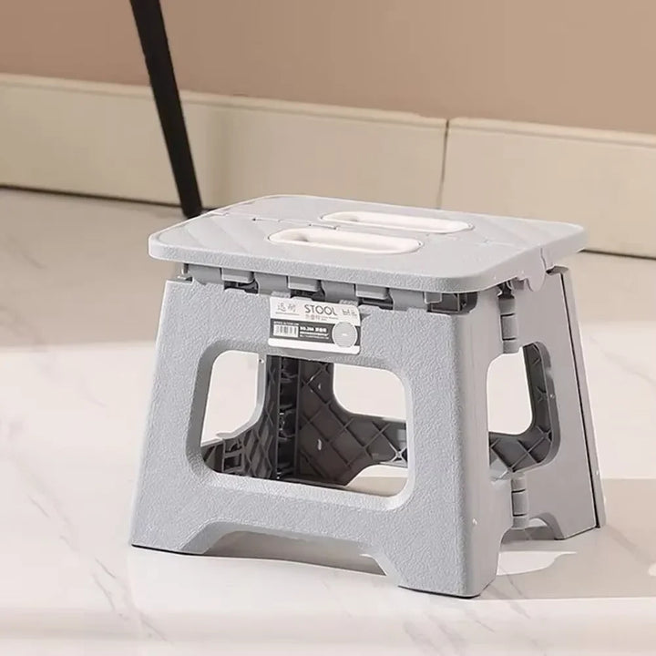 Unisex folding step stool, durable plastic, non-slip grip for secure kitchen assistance.