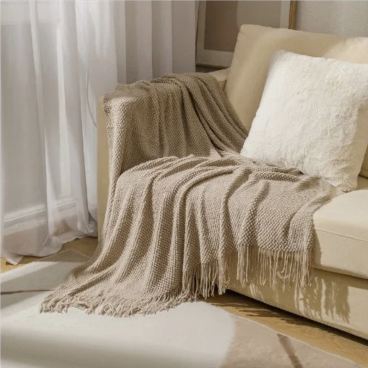Cozy merino-style throw blanket, soft and comfortable acrylic with tassels for living room or bedroom decor.
