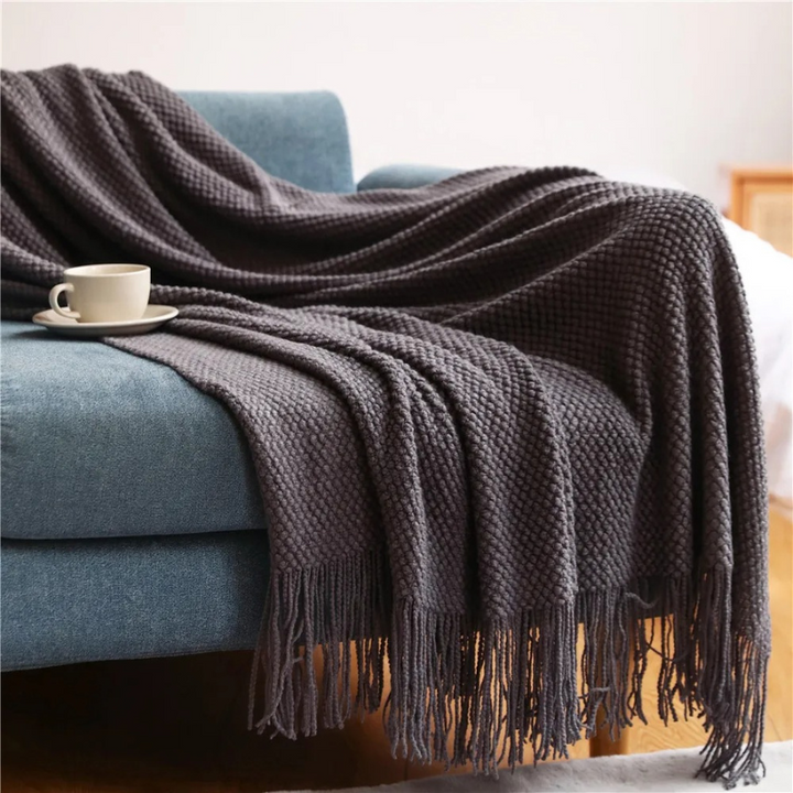 Elegant merino-style blanket with decorative tassels, a soft acrylic throw perfect for stylish home decor.