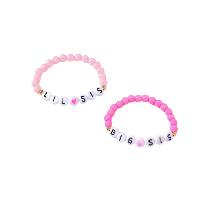 Close-up of matching beaded sister & friend bracelets, each with a silver-tone heart charm. Adjustable fit.