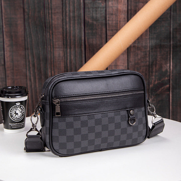 Close-up of men's premium black checked leather messenger bag. Durable, stylish crossbody for essentials.