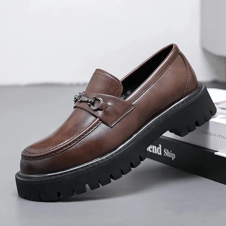 Men's black slip-on loafers with elegant metal buckle, perfect for smart casual or business attire.