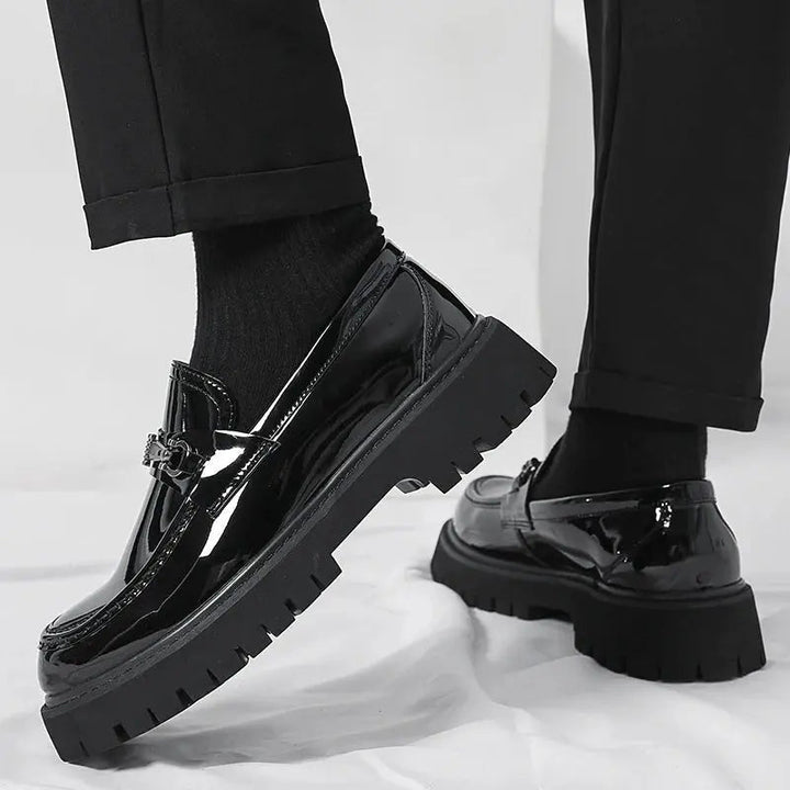 Sophisticated black slip-on loafers for men, with a polished metal buckle, perfect for formal occasions.