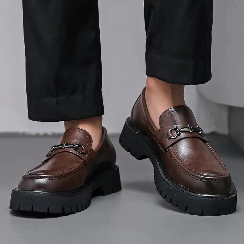 Refined black mens loafers, slip-on design with a prominent metal buckle, suitable for business attire.