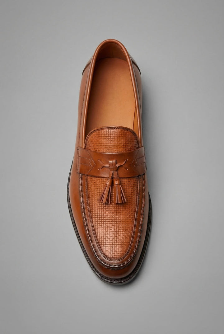Modern men's formal loafers with a unique woven texture and decorative tassels.