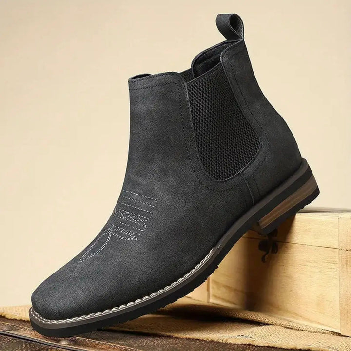 Men's sophisticated black Chelsea boots, pull-on ankle design with subtle western stitch detail for modern appeal.