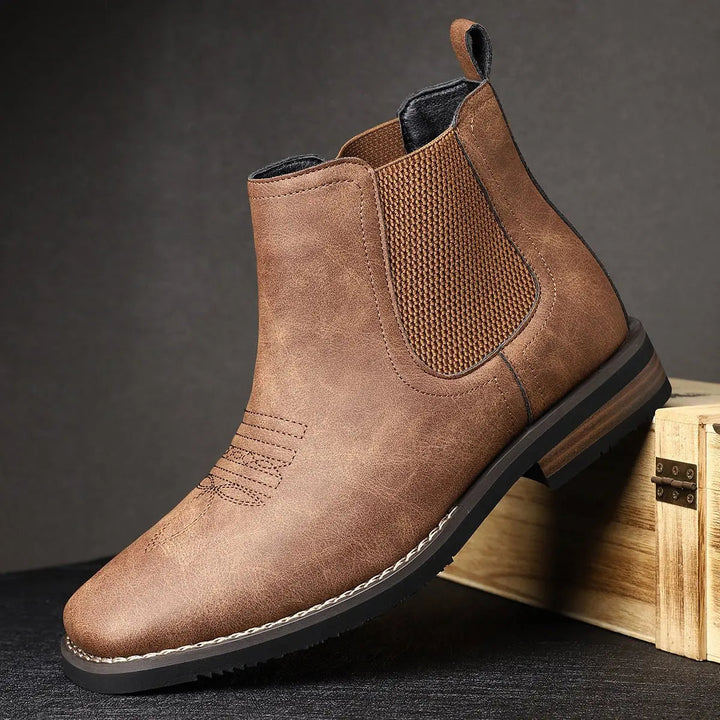 Men's rugged brown leather Chelsea boots, slip-on ankle style with durable block heel and western stitch.