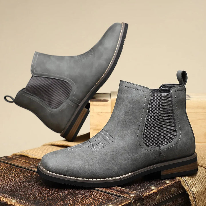 Side view of men's elegant suede Chelsea boots, highlighting western stitch & elastic panels for easy pull-on.
