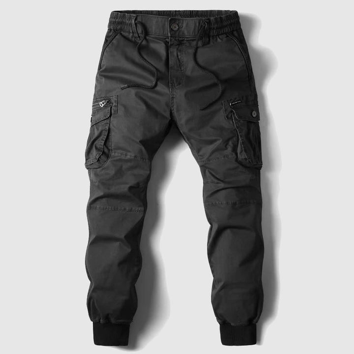 Black men's cargo joggers. Stylish utility pants with multiple pockets & elastic waist for streetwear.