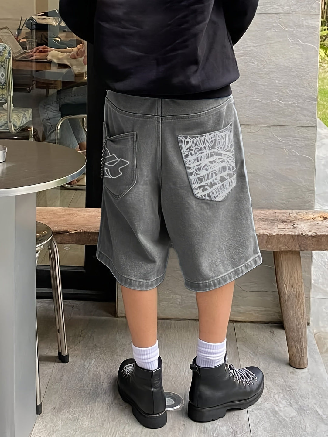 Men's casual denim Bermuda shorts with intricate floral embroidery design.